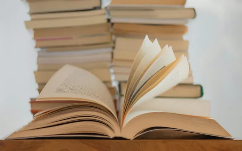 Open book resting on a stack of books