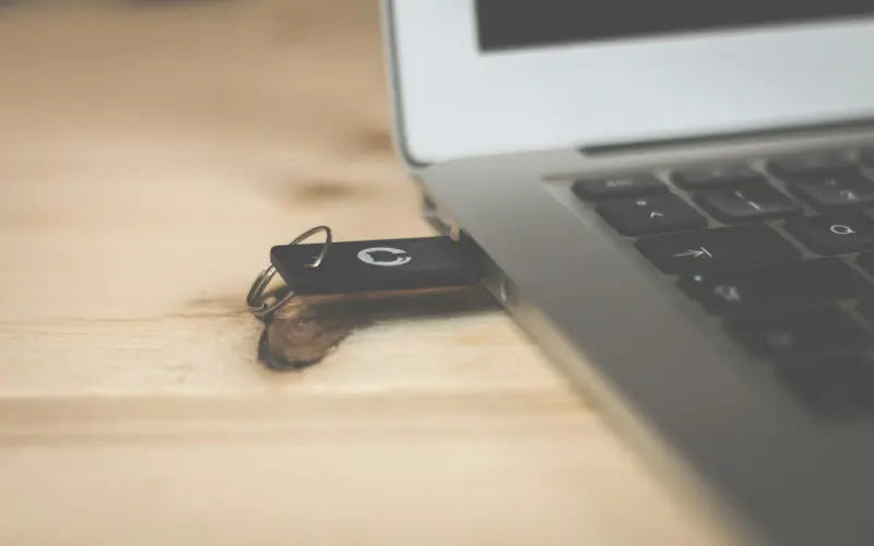 USB token plugged into a laptop on a wooden desk
