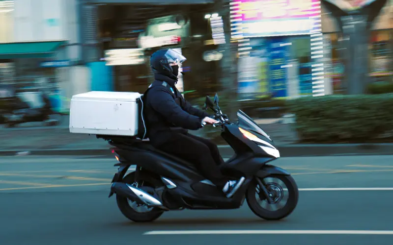 Delivery rider on a scooter carrying a food box